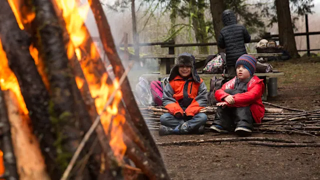 Campers warming up by the winter bonfire