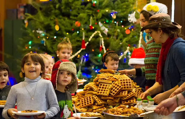 Campers at the winter waffle feast by the tree