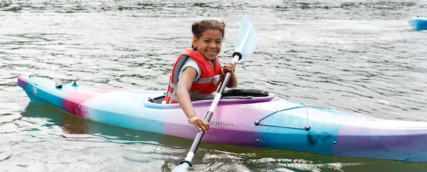 Summer campers paddling kayaks